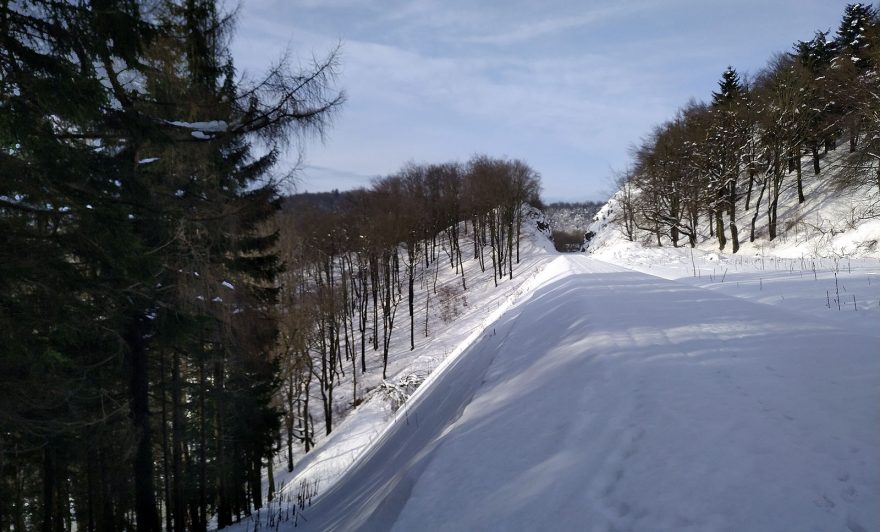 Na skialpech po železničním svršku s výhledem na svah, co nemá ani třicet stupňů