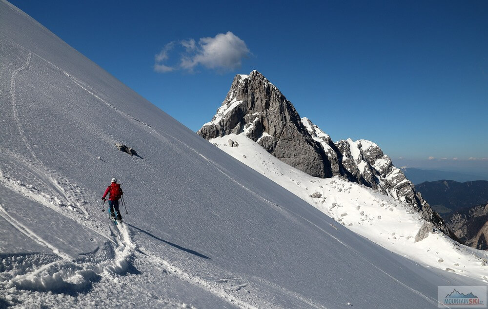 Místy byl sníh už rozbředlý - v pozadí Kotova špica (2376 m). Skialpinistická túra nad Kotovo sedlo pod severními srázy Jalovce v Julských Alpách.