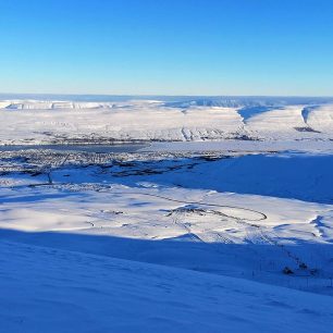 Zasněžené kopečky nad městem Akureyri