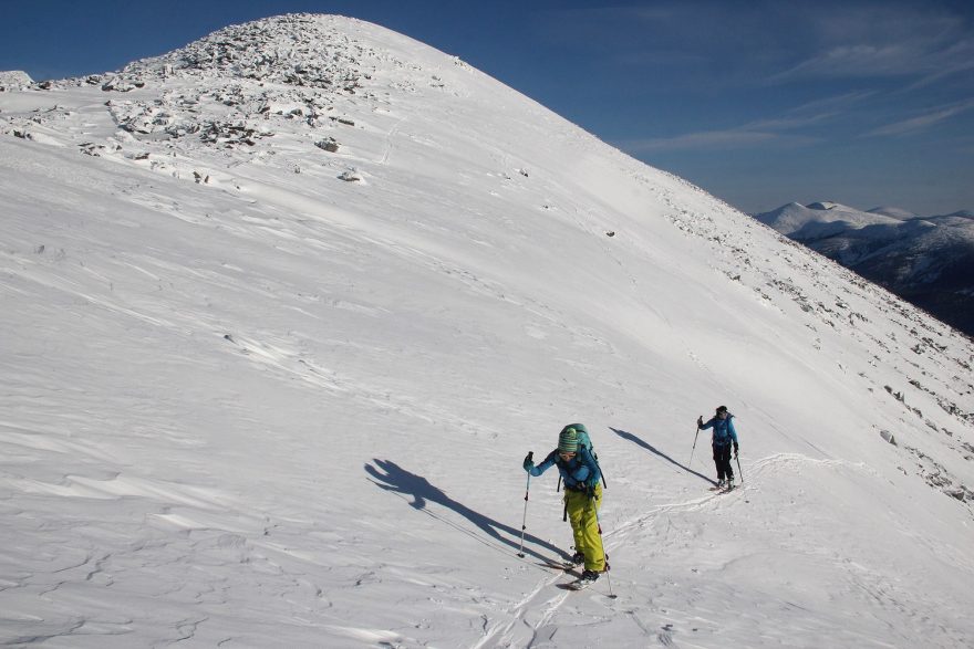 Splitboardiska a skialpinistka stoupající na vyfoukaný sibiřský hřeben