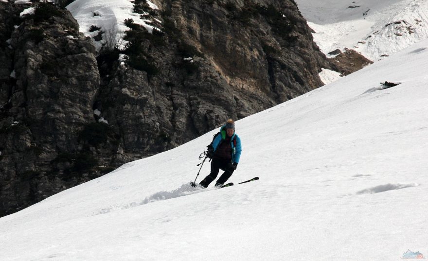 Široká sjezdovka pod žlabem vedoucí k potočnímu zářezu