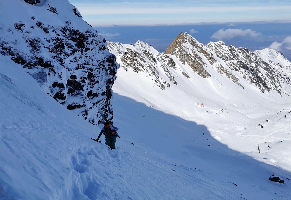 Výstup do sedla u hory Iezerul Caprei (2418 m), strmost a struktura sněhu nedovoluje pokračovat na lyžích. Je dobré je vynést pod převis a dále buď po svých do sedla, nebo s lyžemi na zádech pokračovat dál